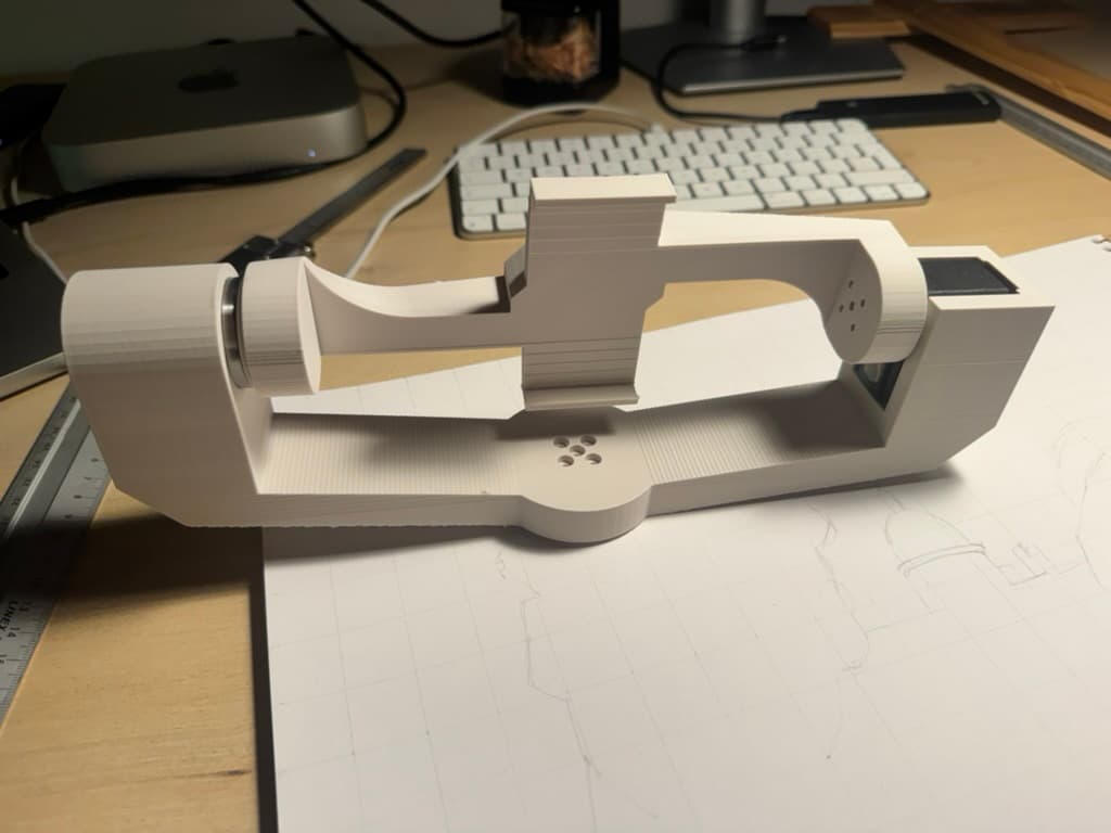 An early 3D-printed pan-tilt mount on a desk, resting on a pencil sketch